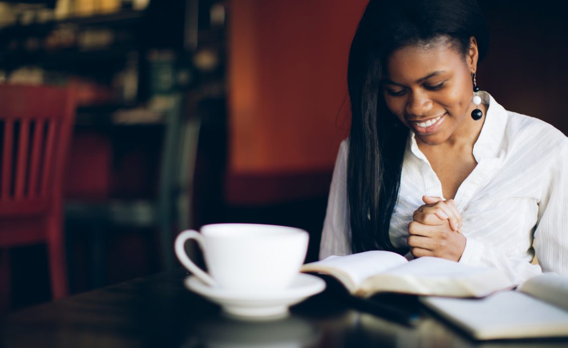 Woman reading bible with coffee thinking of gifts, prayers, and blessings
